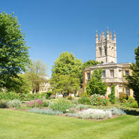Botanic garden view of lawn and flower bed with Magdalen College tower in the background